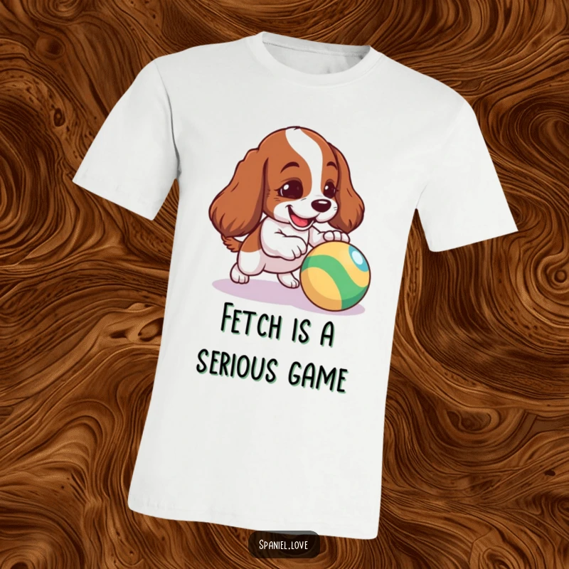 Funny Spaniel T-Shirt: A mischievous spaniel puppy energetically nudging a bright, bouncing ball, capturing pure joy.