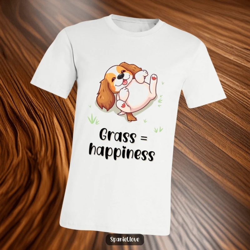 Funny spaniel rolling excitedly on its back in grass on a T-shirt, depicting uninhibited canine joy and playfulness.